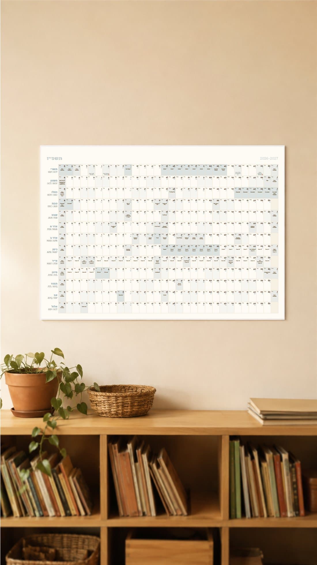 Yearly wall calendar with every Hebrew month and its civil dates, hanging above a bookshelf